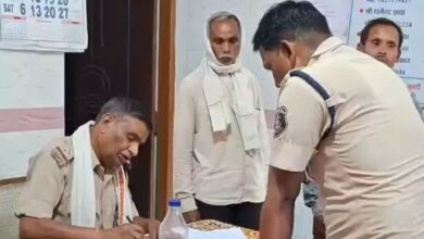 एक सड़क पर खड़ी पीली जेसीबी मशीन और उसके पास पुलिस और स्थानीय लोगों की भीड़