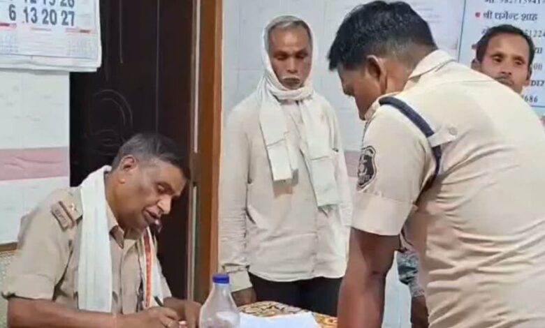 एक सड़क पर खड़ी पीली जेसीबी मशीन और उसके पास पुलिस और स्थानीय लोगों की भीड़
