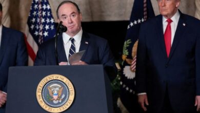 अमेरिकी नौसेना के युद्धपोत की तस्वीर और बैकग्राउंड में पेंटागन की इमारत के साथ नेवी चीफ का धुंधला चित्र