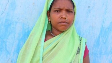 Woman in green scarf against blue background
